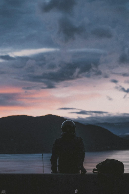 a person standing on top of a hill next to a lake