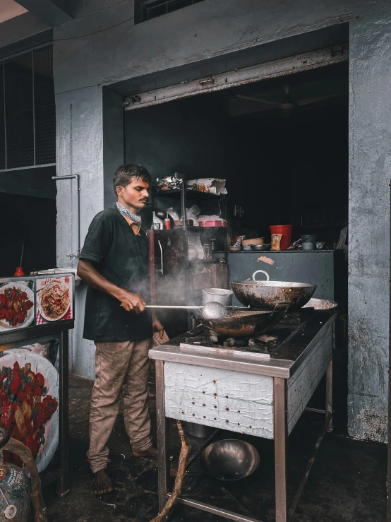 a man preparing food in a kitchen on top of a stove