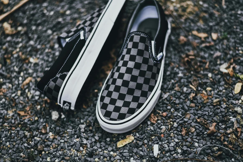 two vans shoes on top of the ground