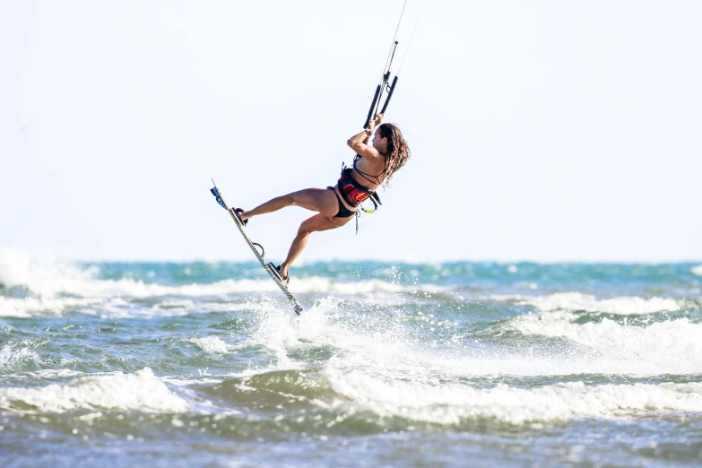 a woman kite surfing in the ocean on a sunny day