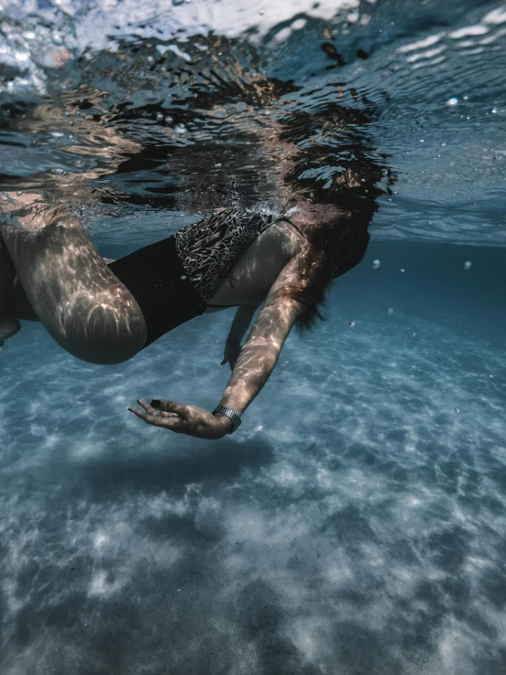 the underwater woman is swimming in a clear body of water