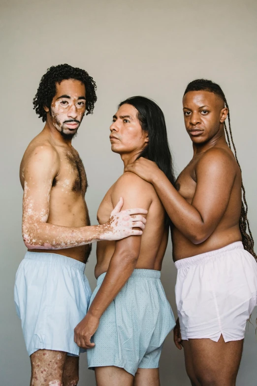 three men and women standing side by side, the other with makeup smeared on his face