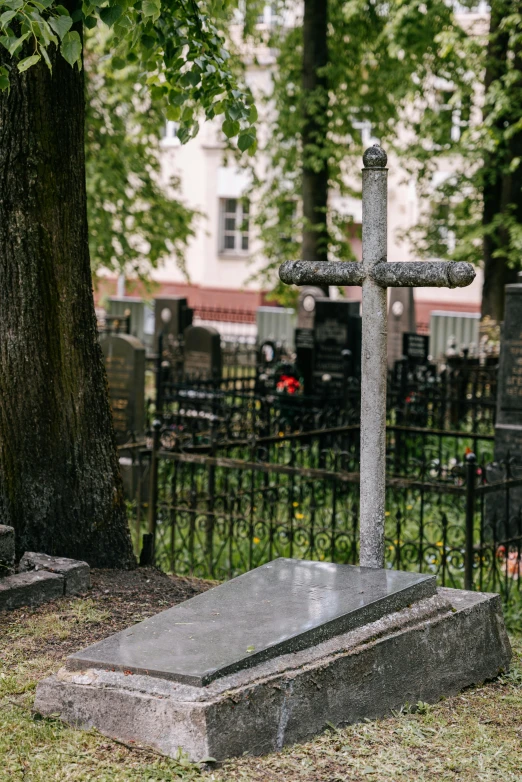 an iron cross is sitting next to a grave