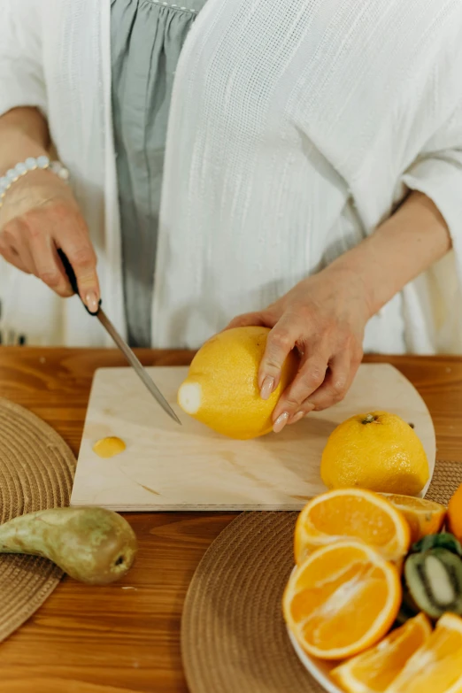 the woman is  oranges on a wooden board