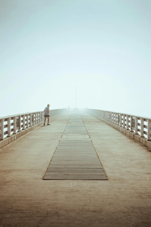 a man standing on a bridge next to the beach