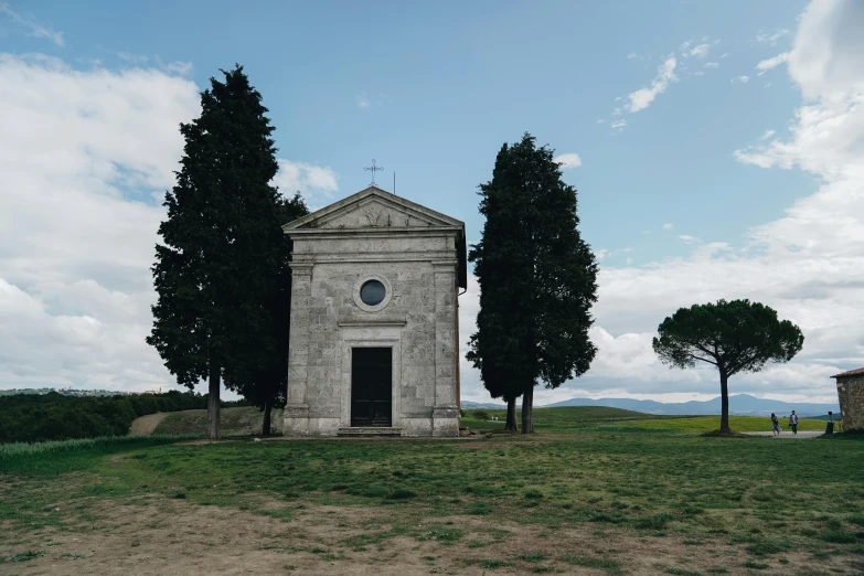 a small church with three trees around it