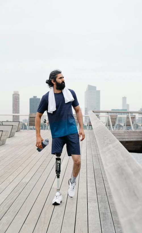 a man with a cast on his arm walking across a dock