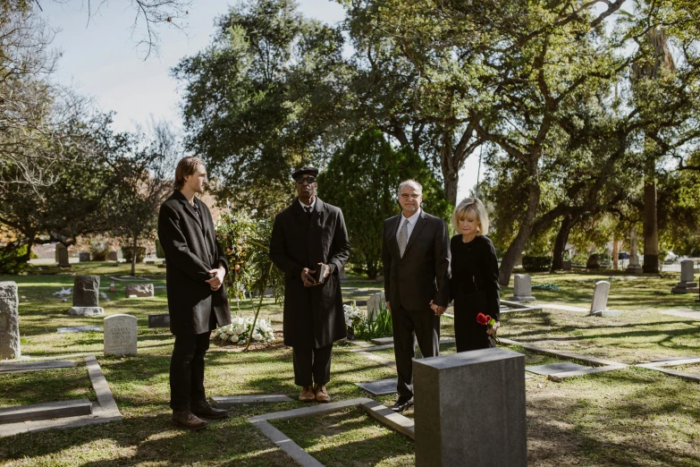 a group of people standing in the middle of a cemetery