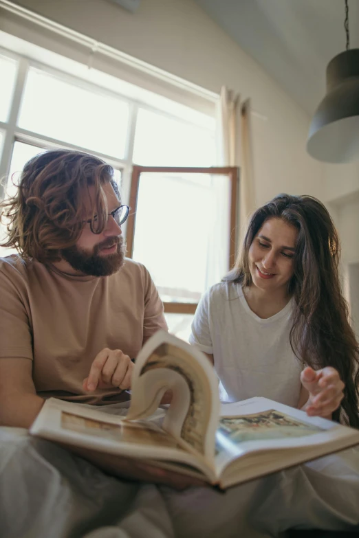 the man is showing off his book to the woman