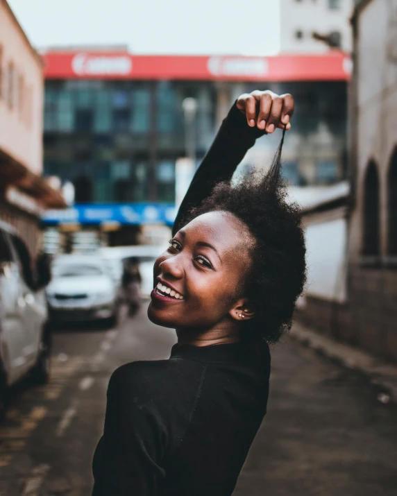 a girl standing outside a building with her hair in the air