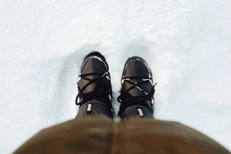 the person is standing in the snow with their shoes on
