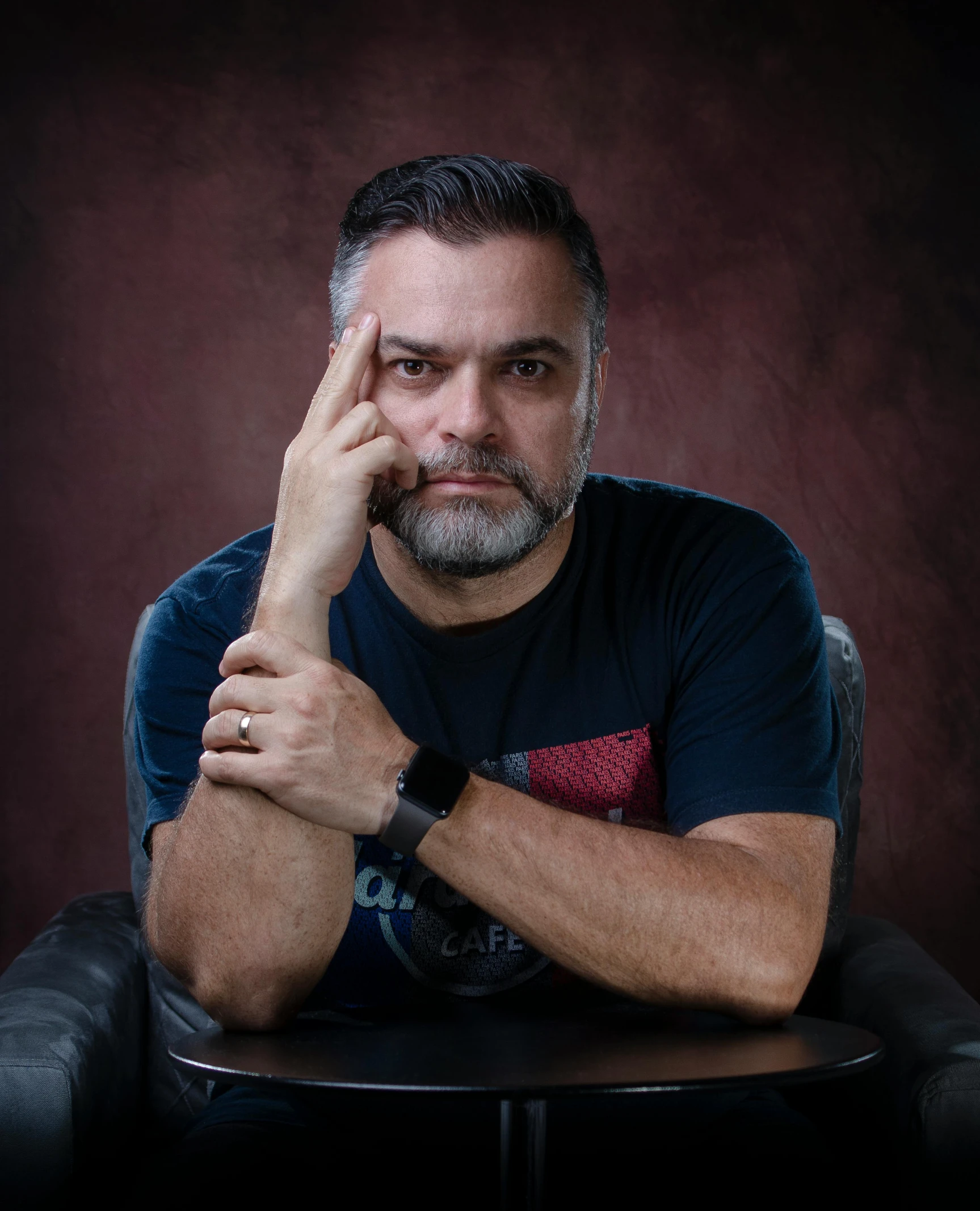 man sitting on a chair holding his hand up to his face