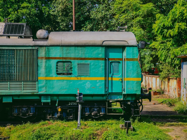 a green train that is sitting in the grass