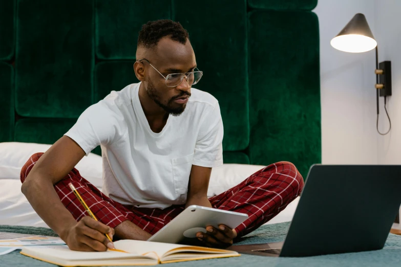 the young man is studying while on his laptop