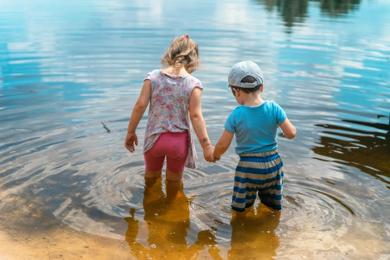 the two s are holding hands as they stand in the water