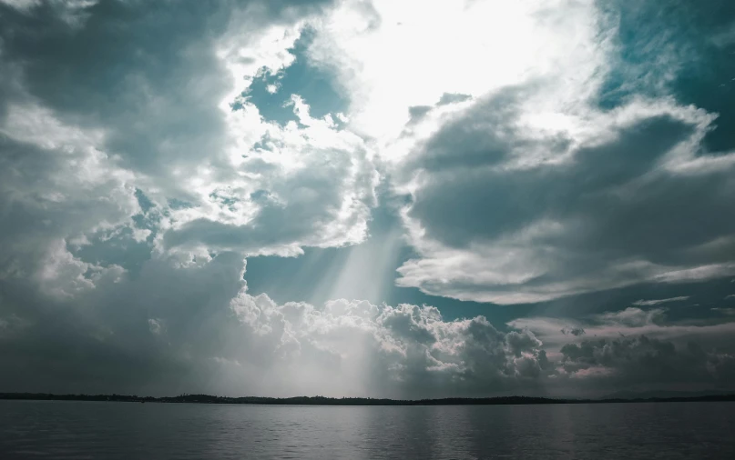 a dark ocean with clouds over it