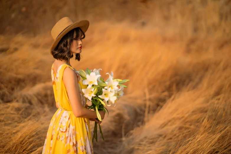 a beautiful young woman in a straw hat holding white flowers
