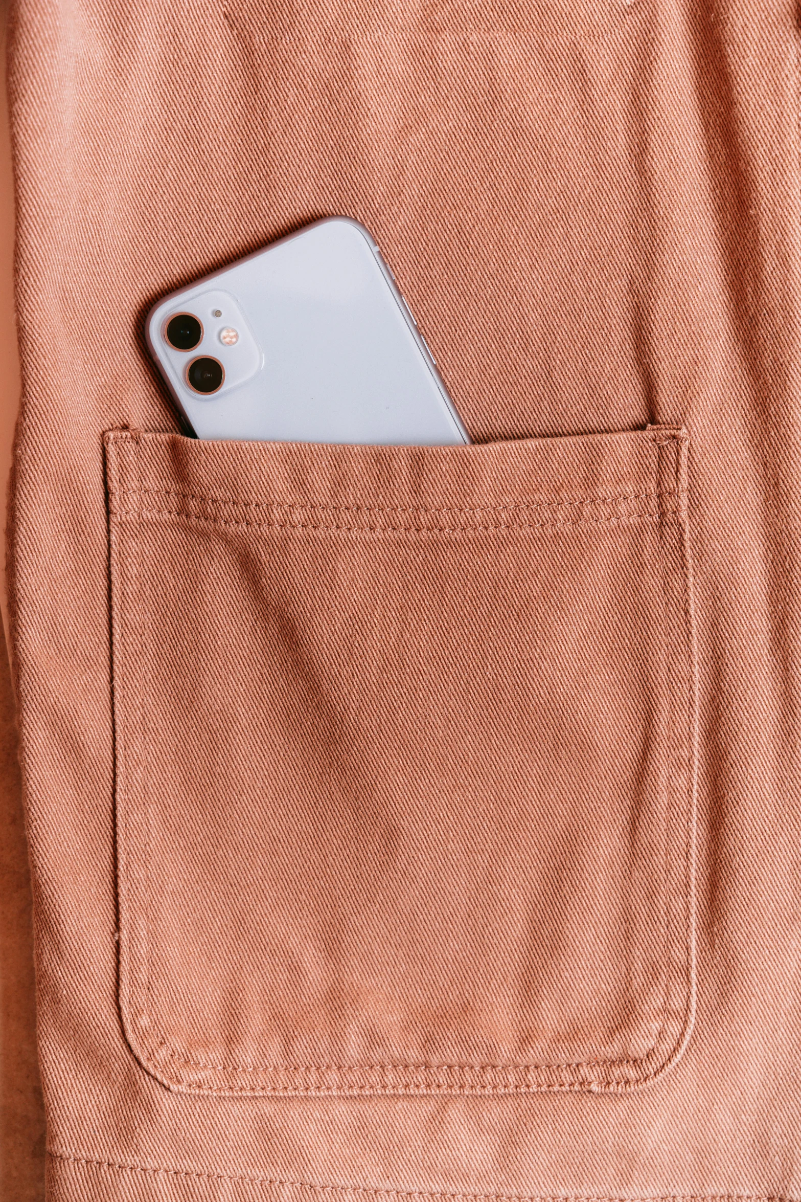 a cell phone is tucked into an orange pocket