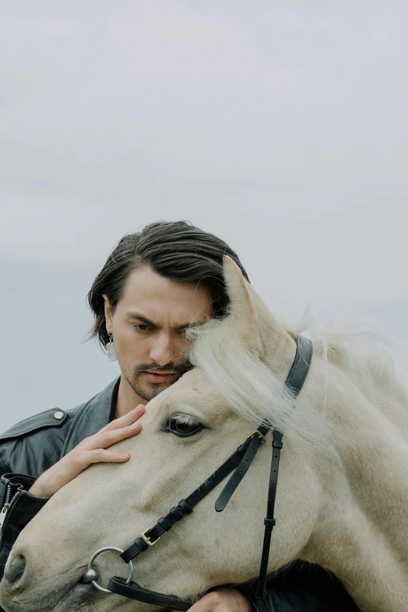 the man is holding onto his white horse