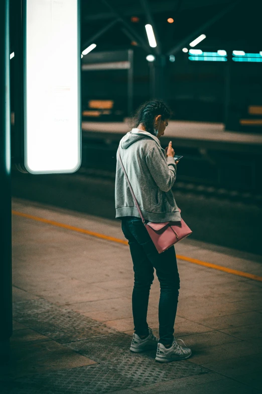 a woman is waiting for the subway to be taken