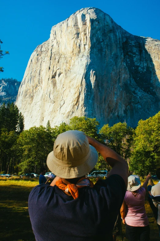 people taking pos of a very tall mountain