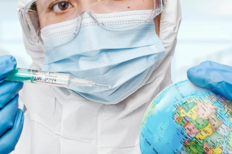 the surgeon is holding the globe and wearing his protective gear