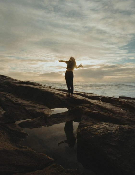 a person standing on top of rocks near the ocean