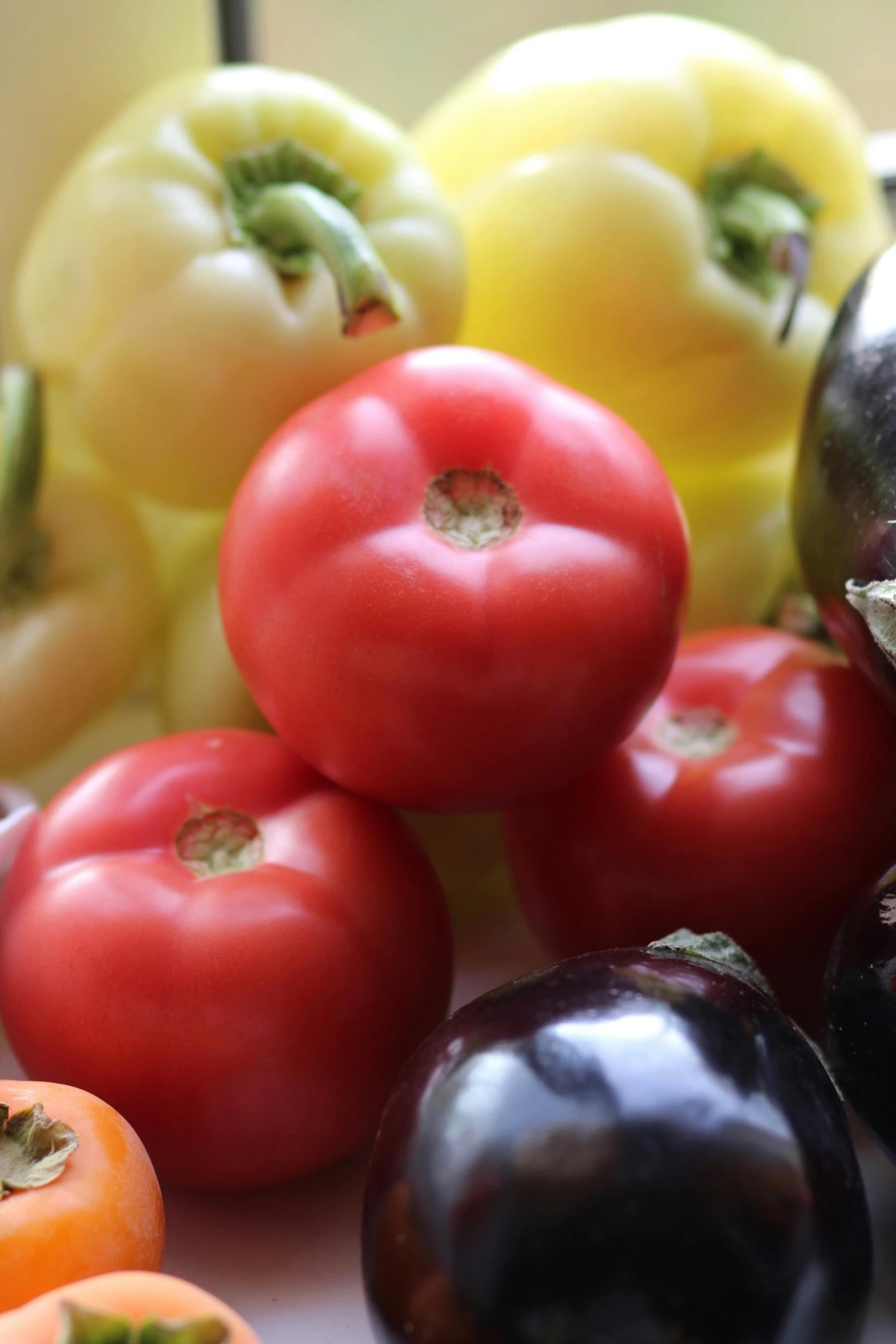 five tomatoes, three with different colors, and one with yellow in them