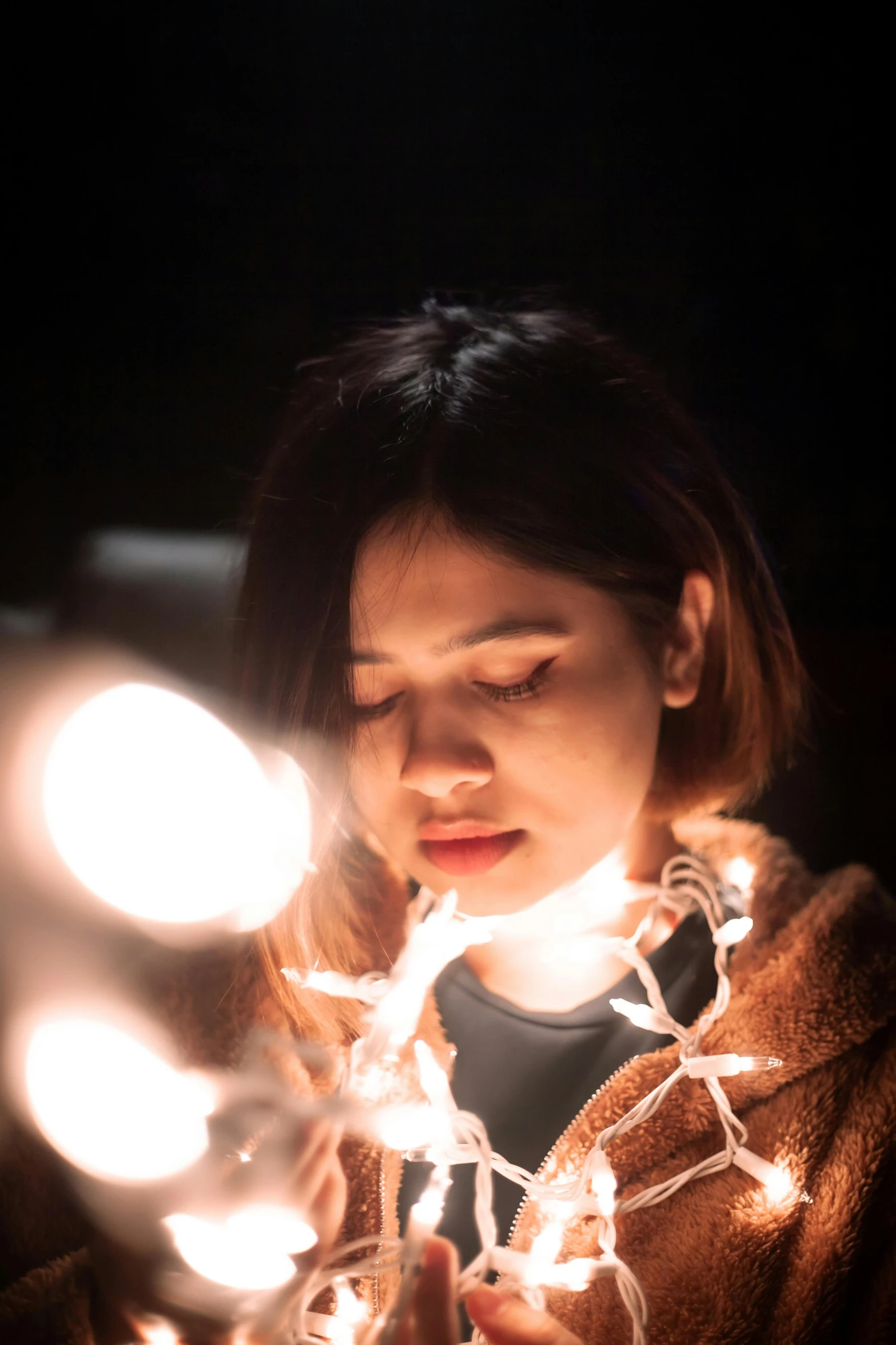 a young woman is lighting up a candle