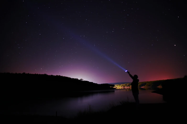 a person holding a light up in the sky