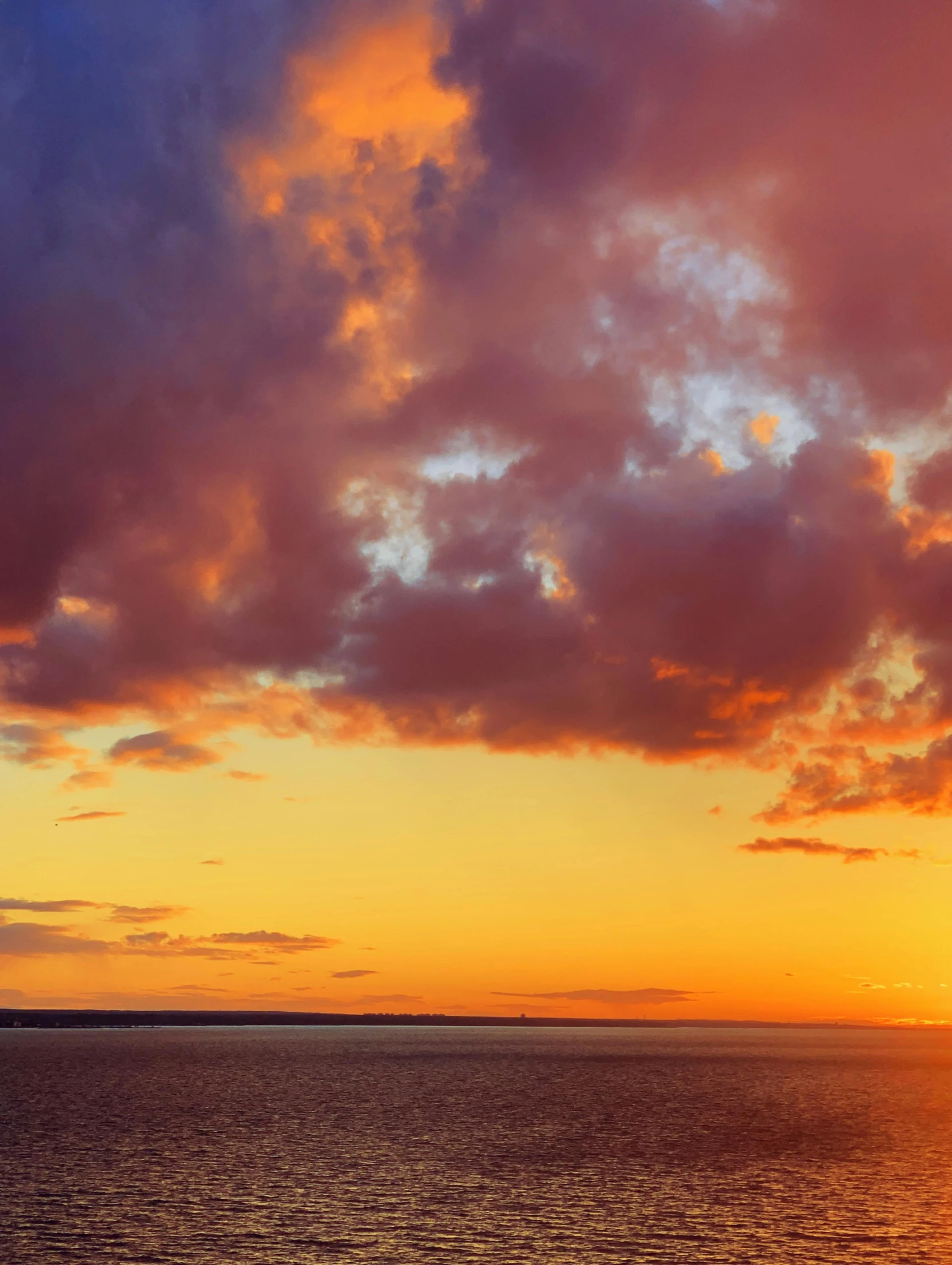 a boat that is floating in the water under a beautiful sunset