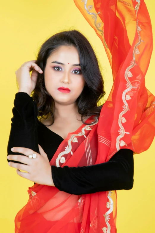 a woman posing for a portrait while wearing an orange scarf