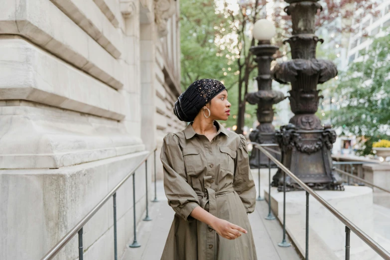 a woman standing on the sidewalk near a lamp post