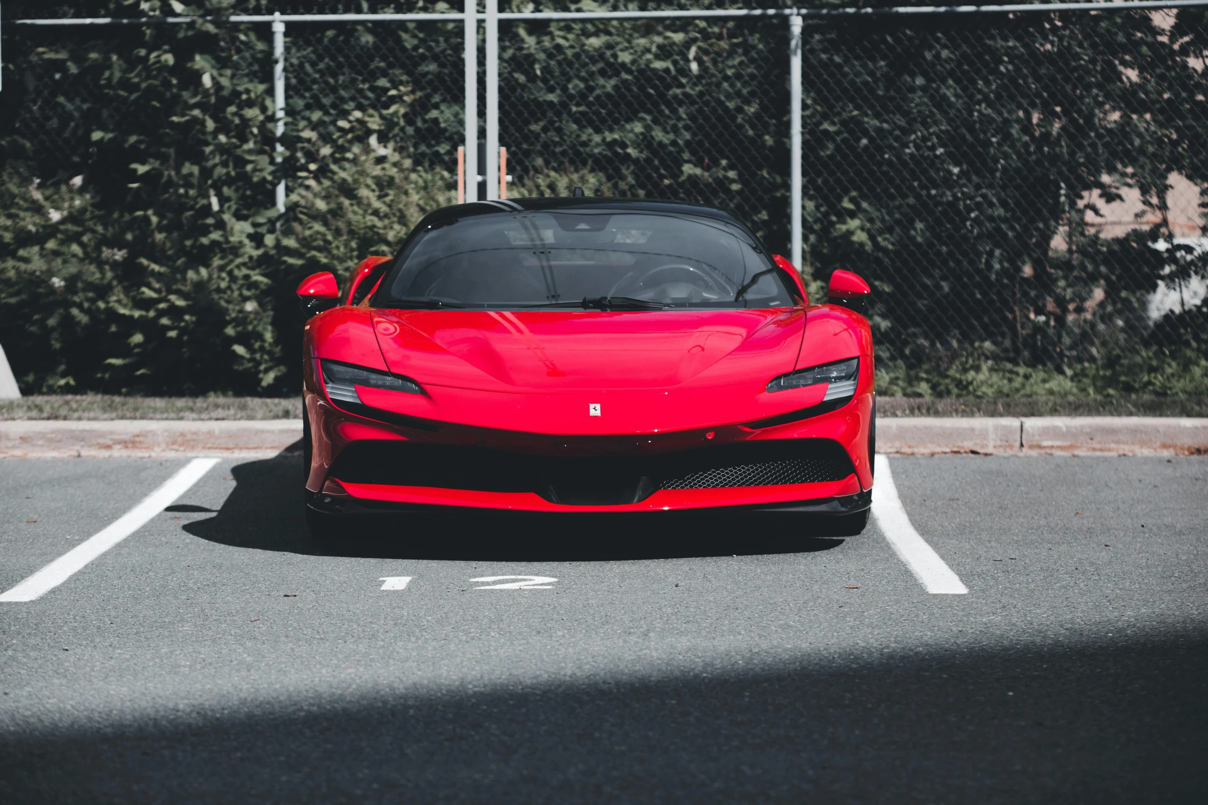 a red ferrari sports car in a parking lot