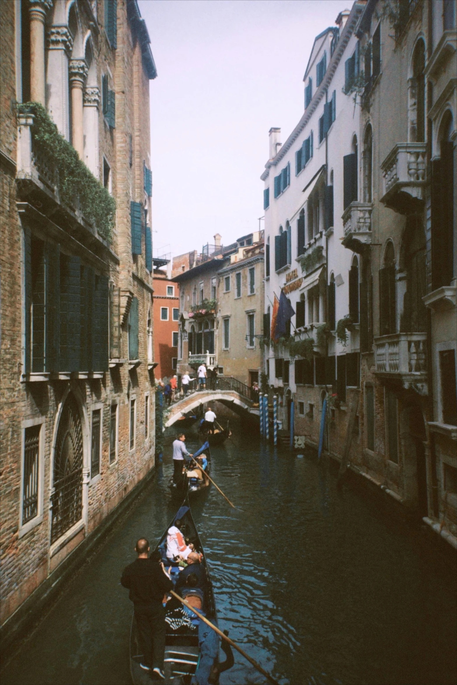 two gondolas sit parked along the water in front of some buildings