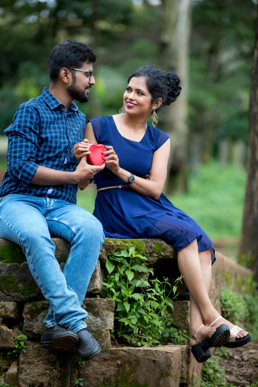 a couple sitting on stone bench in a forest