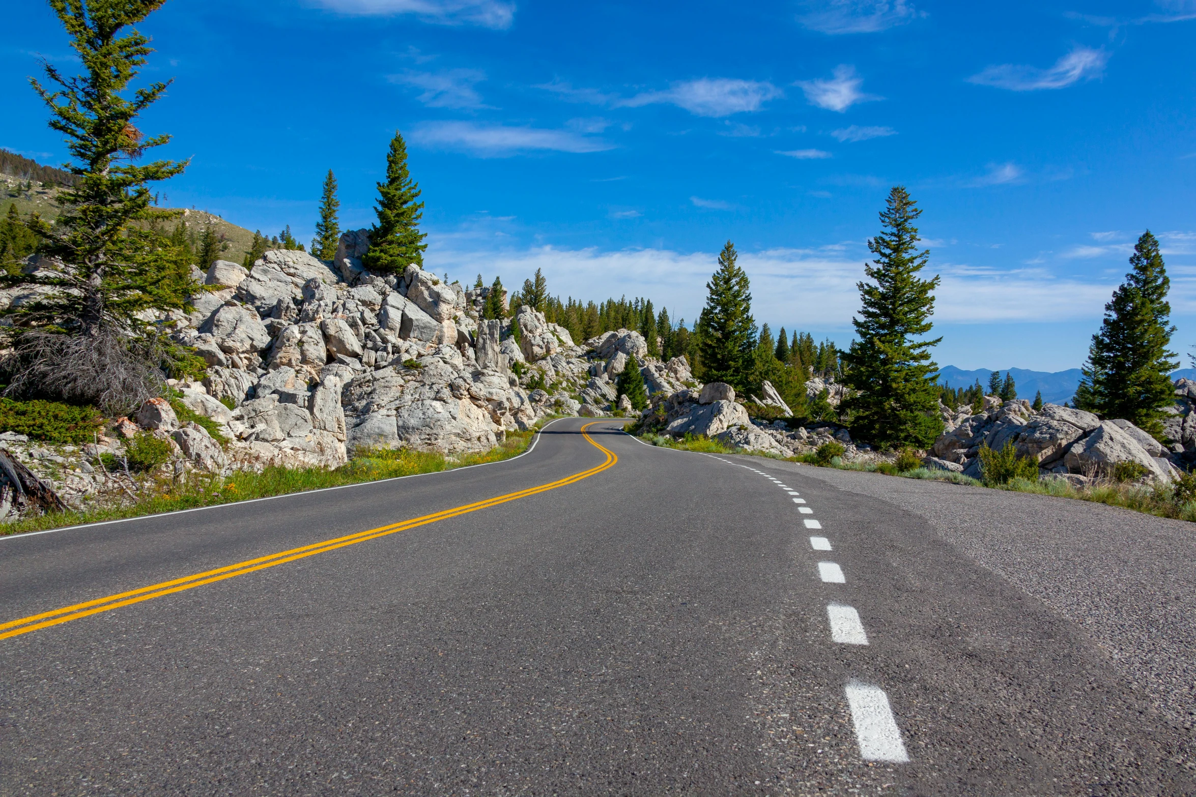 a single yellow line down the road going uphill