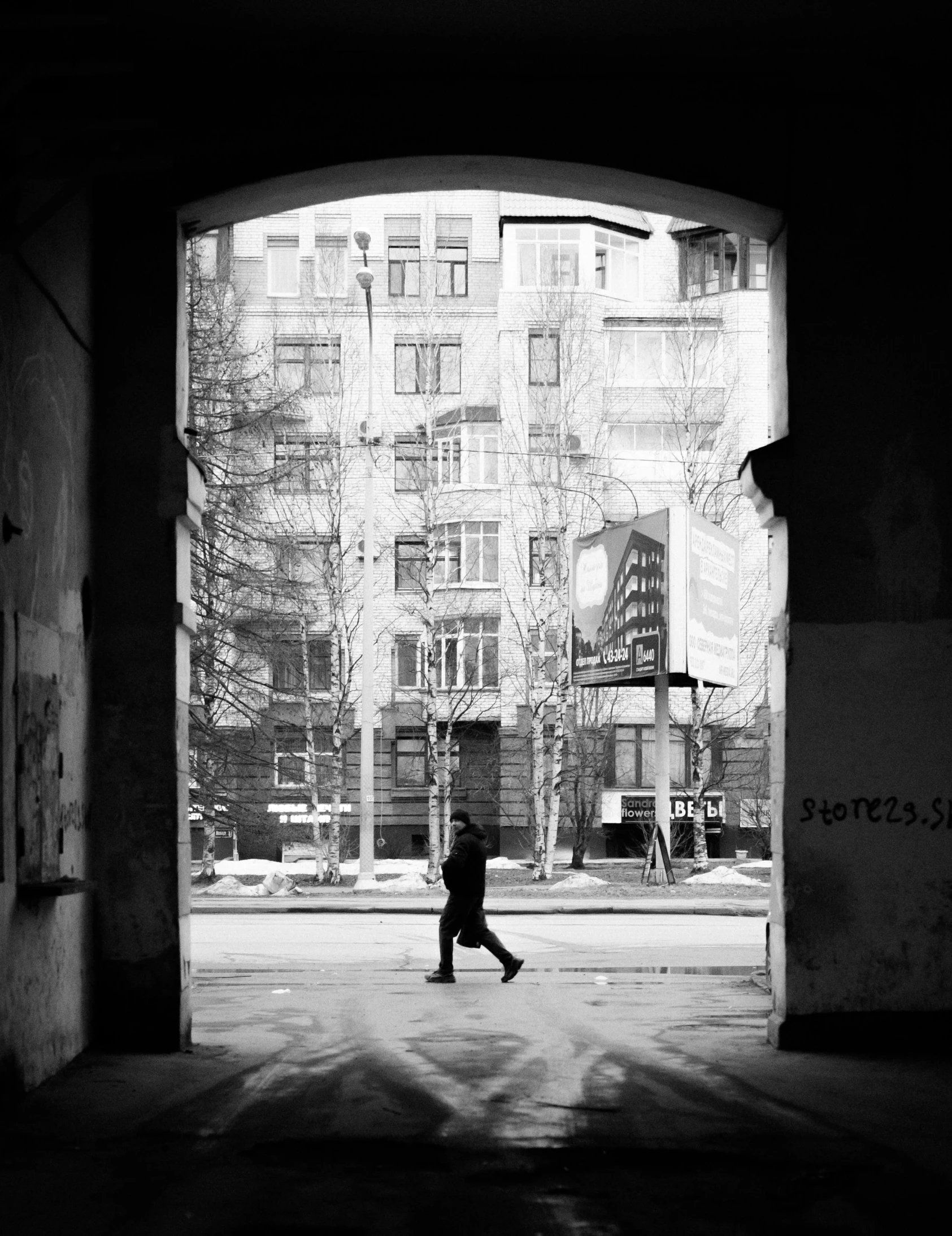 a person walking across a road holding an umbrella