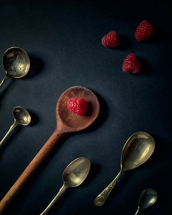 a couple of spoons with raspberries on top