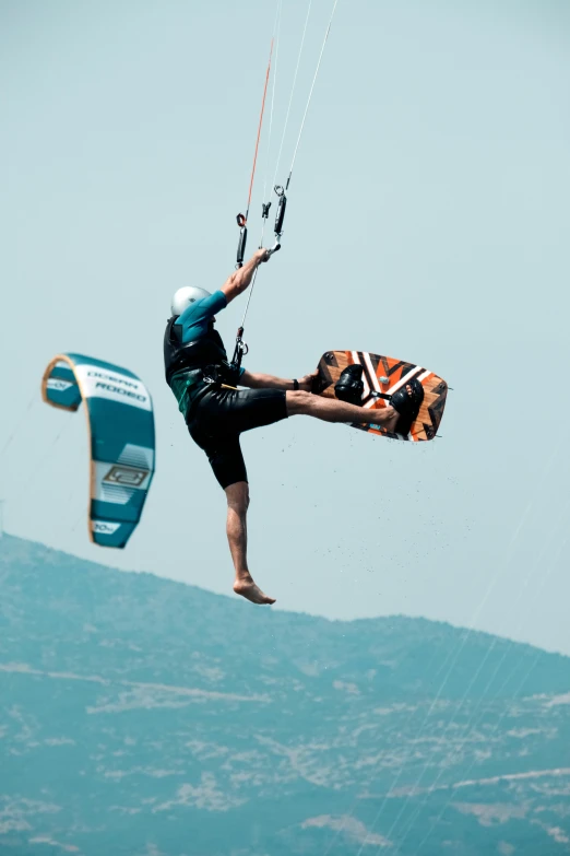 a person jumping into the air while holding onto a parachute