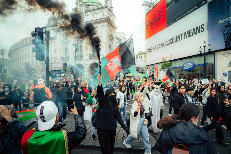 protesters in the street with smoke and black smoke from a green black and white flag