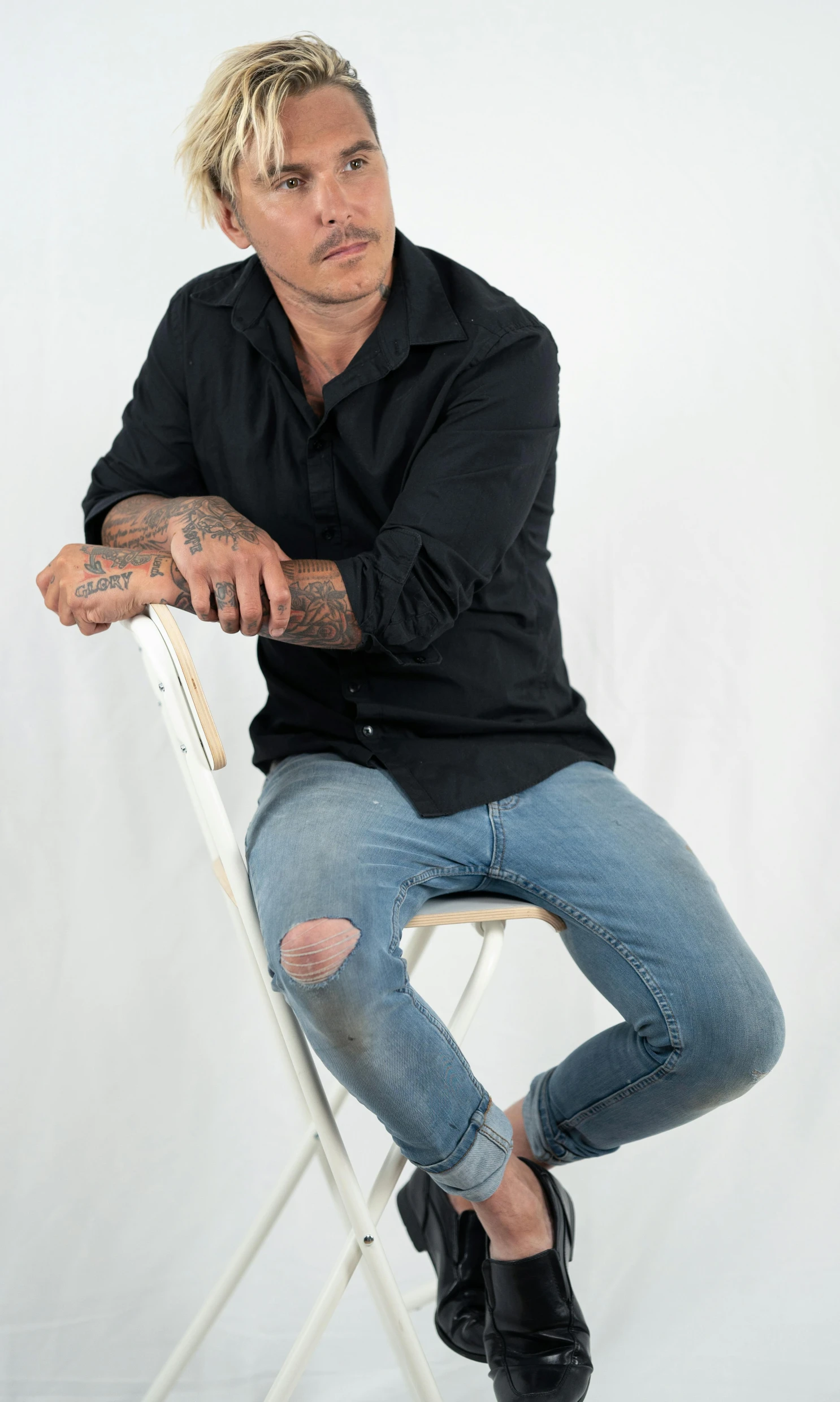 man in black shirt sitting on white folding chair