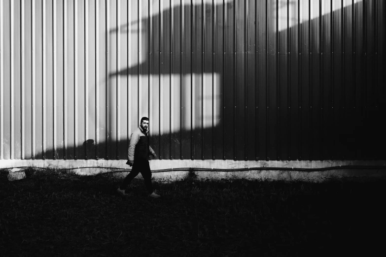 black and white po of a person walking down a sidewalk