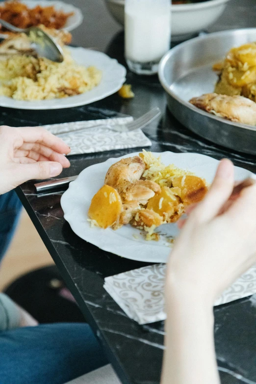 three people are sharing plates with one another