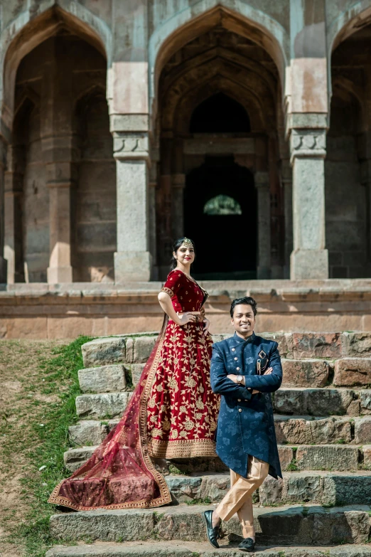 the bride and groom pose on the steps of an old building