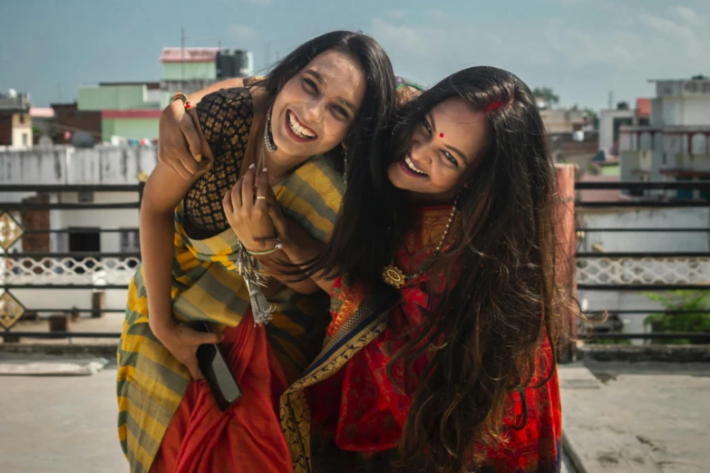 two women hugging each other outdoors in a courtyard