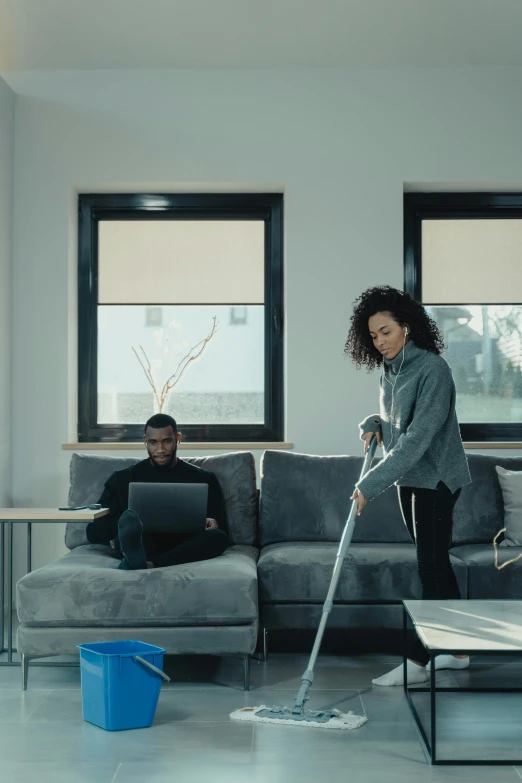 a person using a vacuum mop in the middle of a living room