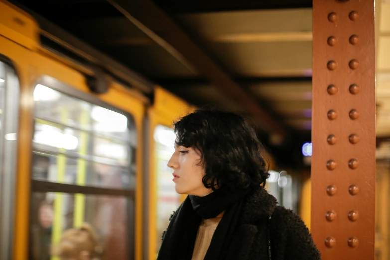 a young woman standing on the train platform