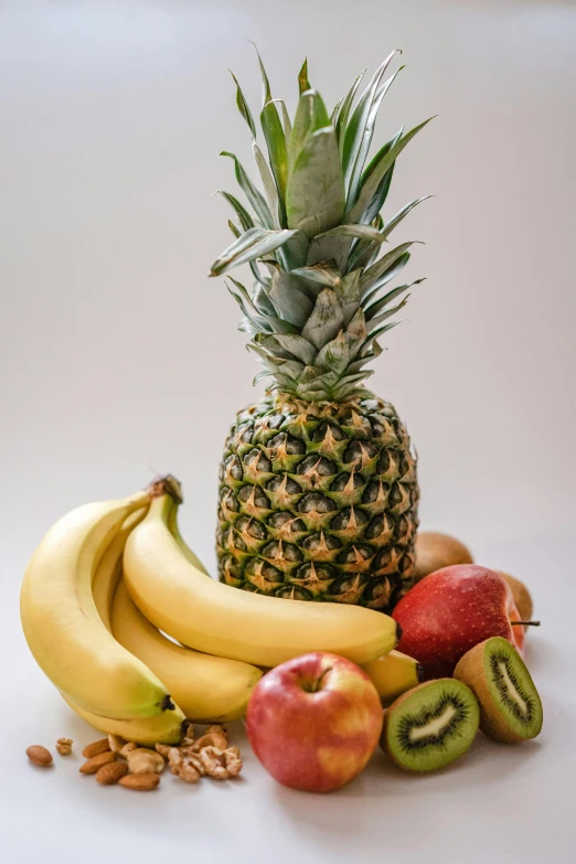 a close up of a pineapple with other fruit in front
