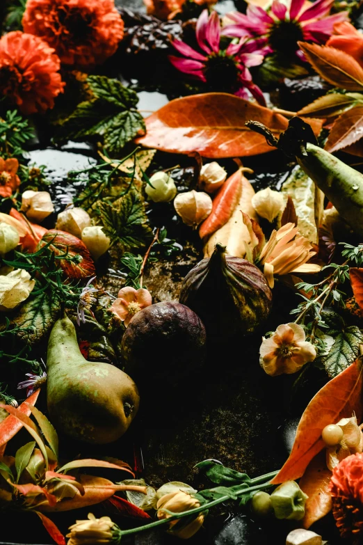 a pile of autumn vegetables next to autumn flowers